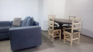 a living room with a blue couch and a table and chairs at Aire Urbano in Resistencia