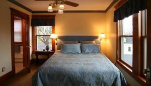 a bedroom with a large bed with two windows at Breezy Hill Inn in Fleischmanns