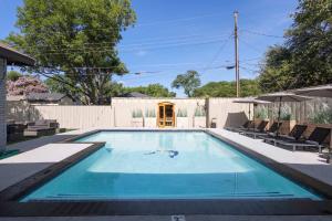 a swimming pool in a backyard with chairs and a fence at Family Paradise Playhouse includes Pool and Gameroom in Dallas +44 photos