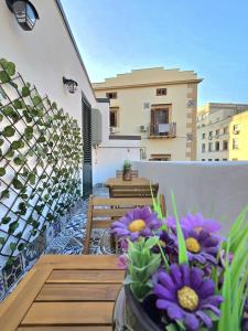 a balcony with a table and some purple flowers at Angelina Rooms in Palermo