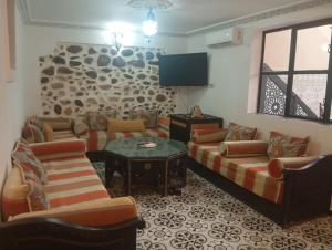 a living room with couches and a flat screen tv at maison piscine privé Lac takerkoust in Lalla Takerkoust