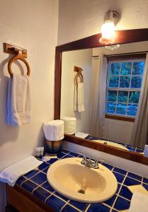 Tranquility Bay Resort في سان بيدرو: حمام مع حوض ومرآة