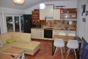 a kitchen with a couch and a table and chairs at Sunny Cottage in Petrcane