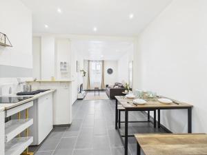 a kitchen with a table and a living room at Sweet stay T2 in Dreux
