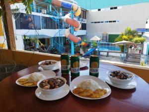 a table with plates of food and bottles of beer at Hotel South Beach Atacames in Atacames