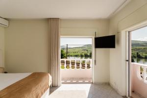 a bedroom with a bed and a large window at Casa do Carril - Private Pool - Douro Valley in Peso da Régua