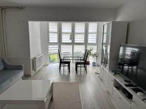 a living room with a table and chairs in it at Apartament Słowiańska by Zilla in Ustka