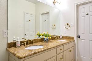 a bathroom with two sinks and a large mirror at Cozy Lakehouse + Boat Access in Enchanted Oaks +33 photos