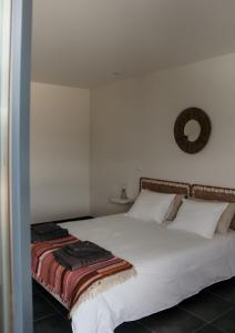 a bedroom with a bed with white sheets and pillows at Canhoto Douro in São Lourenço do Douro