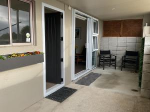 an open door of a house with a patio at Spacious Studio - Self Contained in Tauranga