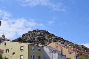 a mountain in the middle of a city with buildings at Pisos A Barca in Muxia
