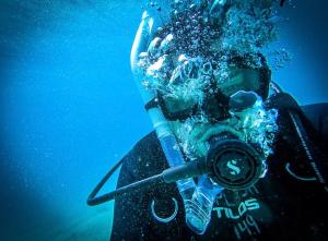 Tranquility Bay Resort في سان بيدرو: شخص يحمل كاميرا في الماء
