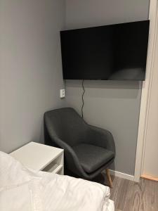 a bedroom with a chair and a tv on the wall at CityBed Bed & Breakfast in Pajala