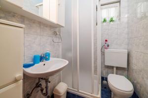 a bathroom with a white sink and a toilet at Apartment Vlatka Grof in Selce +36 photos