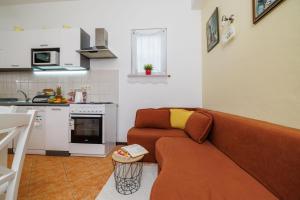 a living room with a couch and a kitchen at Apartment Vlatka Grof in Selce