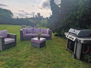 a backyard with three couches and a grill and a grill at Cozy apartment Rose in Fjälkinge