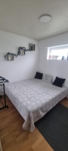 a bed in a room with a white wall at Cozy apartment Rose in Fjälkinge