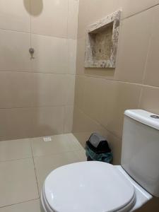 a bathroom with a white toilet and a shower at Hotel Manarela in Imperatriz