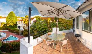 a patio with a glass table and an umbrella at El paraiso en Melgar in Melgar