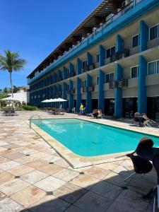 a swimming pool in front of a hotel at Marinas Vista Mar in Tamandaré