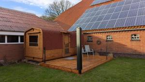 a house with a deck with solar panels on it at Ferienhaus Gulfhof Tjaden in Großefehn  +8 photos