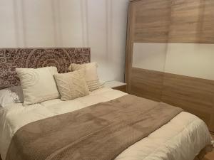 a bedroom with a large bed with a wooden headboard at Piso acogedor en Barbate in Barbate