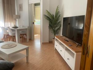 a living room with a flat screen tv on a dresser at Piso acogedor en Barbate in Barbate +14 photos