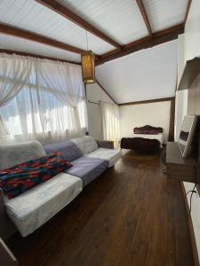 ein Wohnzimmer mit Sofa und Fernseher in der Unterkunft Linda casa de praia 5km Beto Carrero - Gravatá. 300 metros da praia!! in Navegantes