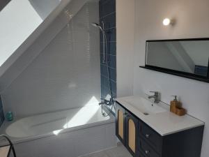 a bathroom with a bath tub and a sink at Maison Saint Philibert 3 chambres in Saint-Philibert +14 photos