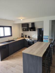 a kitchen with a large wooden island in the middle at Maison Saint Philibert 3 chambres in Saint-Philibert