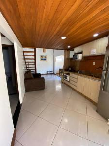 eine große Küche mit Couch und Holzdecke in der Unterkunft Linda casa de praia 5km Beto Carrero - Gravatá. 300 metros da praia!! in Navegantes