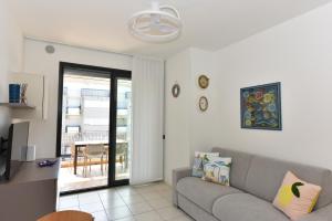 a living room with a couch and a balcony at Casa Grace - SANTA MONICA in Lido di Jesolo