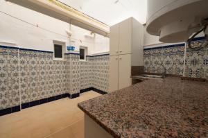a kitchen with blue and white tiles on the wall at Holiday Beach Centro in Santa Pola +23 photos