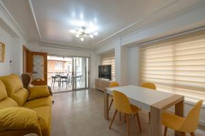 a living room with a couch and a table and chairs at Holiday Beach Centro in Santa Pola