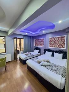 a bedroom with two beds and a purple ceiling at Mitra Downtown Hotel in Istanbul