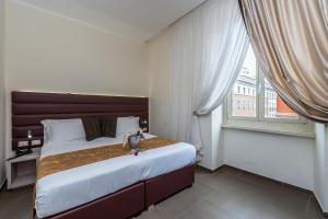 Un dormitorio con una cama grande y una ventana. en Hotel California, en Roma