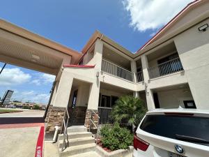 ケイティーにあるScottish Inn and Suitesの建物の前に駐車された車