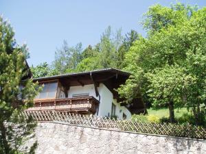 een huis met een stenen muur en bomen bij Ferienwohnung Wörndl in Faistenau