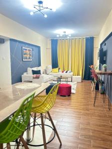 a living room with a couch and a table and chairs at Nana Suites 1-bedroom with Swimming pool & Fast WiFi & Mall in Nairobi +5 photos
