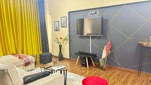 a living room with a couch and a tv at Nana Suites 1-bedroom with Swimming pool & Fast WiFi & Mall in Nairobi