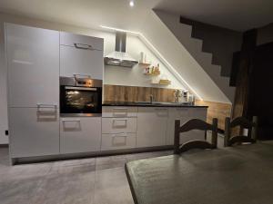 a kitchen with white cabinets and a stove at Chambre 1P à Saint Hubert in Saint-Hubert +2 photos