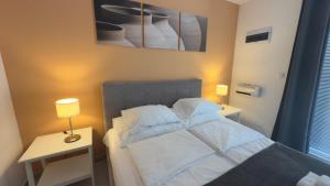 een slaapkamer met een bed en een tafel met een lamp bij Code Srebrno Jezero in Veliko Gradište