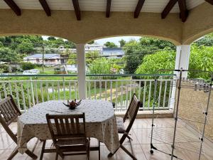 a white table and chairs on a balcony with a view at Colibri studio in Les Abymes +2 photos