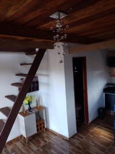 a living room with a wooden ceiling and stairs at Chalé Vista da Serra in Pedro II