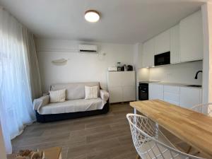 a living room with a couch and a kitchen at Formentera Suite 10 in Es Pujols +7 photos