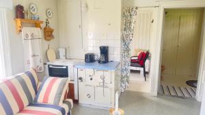 a small kitchen with a stove and a couch at Cozy little house at Byske in Byske
