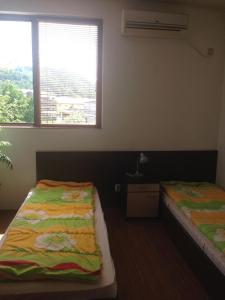 two beds in a room with a window at Apartment Planinski Rai in Tryavna