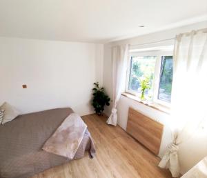 a bedroom with a bed and a window at Domeček pod skokanskými můstky in Frenštát pod Radhoštěm