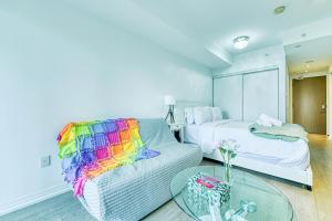 a bedroom with a bed and a couch with a glass table at RivetStays - The Jarvis in Toronto