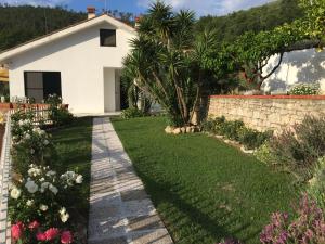 un jardín frente a una casa blanca en B&B Claro de luna, en Tovo San Giacomo